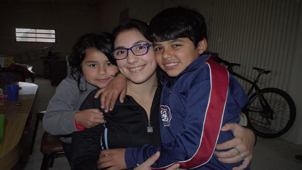 Rocío, voluntaria de El Ventanal, junto a dos de sus alumnos